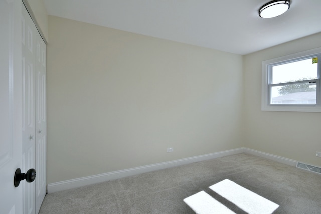 unfurnished bedroom featuring light carpet and a closet