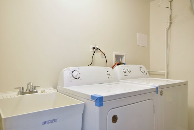 clothes washing area with independent washer and dryer and sink