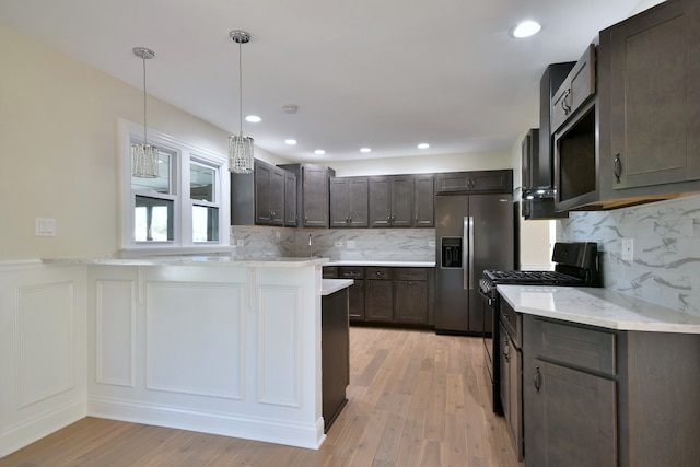 kitchen featuring kitchen peninsula, stainless steel refrigerator with ice dispenser, black gas range oven, and light wood-type flooring