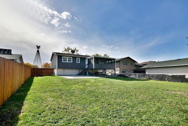 back of house featuring a sunroom, a patio area, and a yard