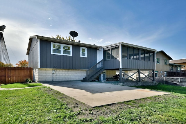 back of property featuring a yard and a sunroom