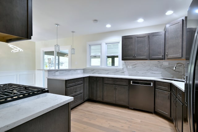 kitchen featuring dishwasher, sink, hanging light fixtures, dark brown cabinets, and light hardwood / wood-style floors