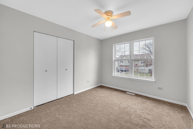 unfurnished bedroom with ceiling fan, a closet, and carpet