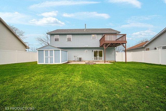 back of property featuring a fire pit, a yard, a storage unit, a patio area, and a deck