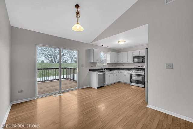 kitchen featuring pendant lighting, white cabinets, sink, light hardwood / wood-style flooring, and stainless steel appliances