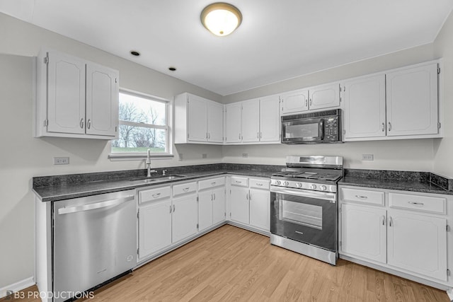 kitchen featuring white cabinets, appliances with stainless steel finishes, light hardwood / wood-style flooring, and sink