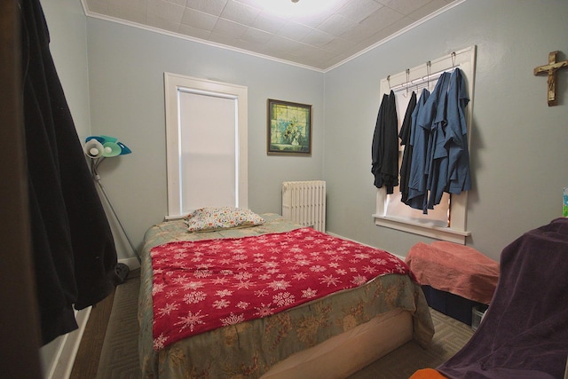 bedroom with crown molding, radiator heating unit, and carpet