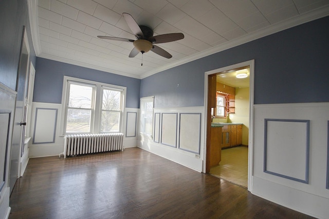 unfurnished room with ceiling fan, dark hardwood / wood-style flooring, crown molding, and radiator