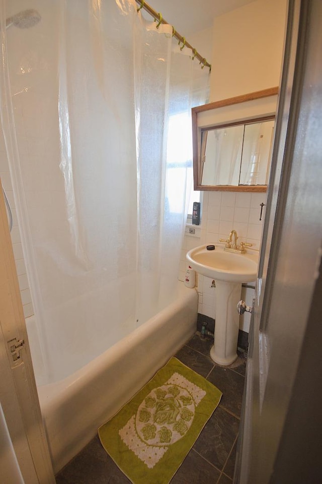 bathroom with tile patterned flooring, shower / bath combo, sink, and tile walls