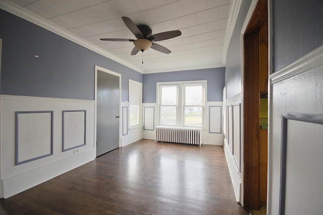 spare room with ceiling fan, wood-type flooring, ornamental molding, and radiator