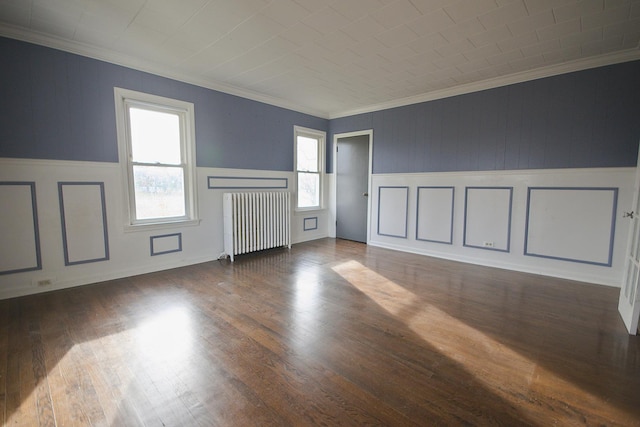 unfurnished room with radiator heating unit, dark wood-type flooring, and ornamental molding