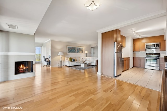 living room with rail lighting and light hardwood / wood-style floors