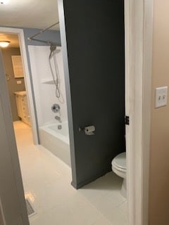 bathroom featuring tile patterned flooring, toilet, and bathtub / shower combination