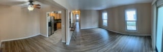 unfurnished living room with ceiling fan and dark hardwood / wood-style flooring