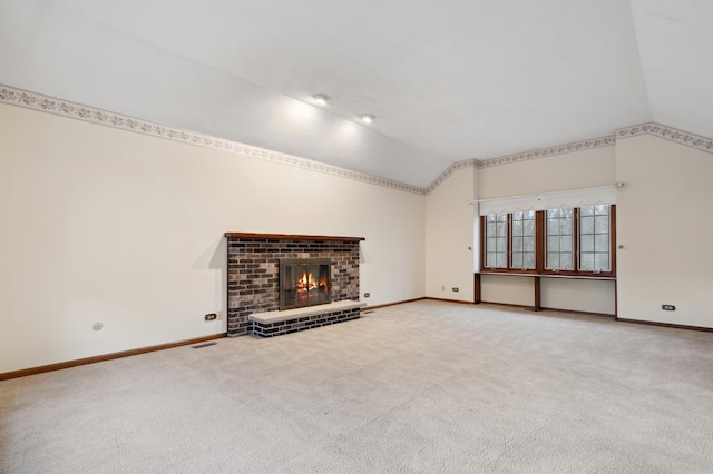 unfurnished living room featuring carpet floors, a brick fireplace, and lofted ceiling