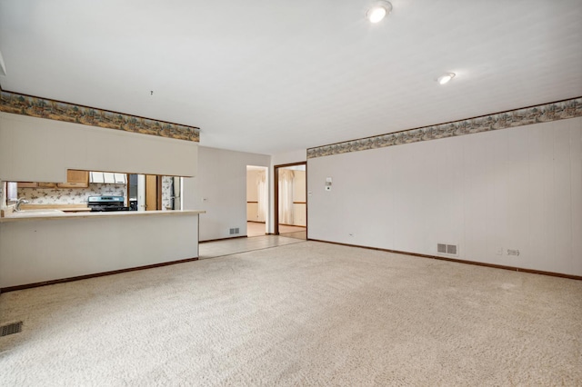 unfurnished living room featuring light colored carpet