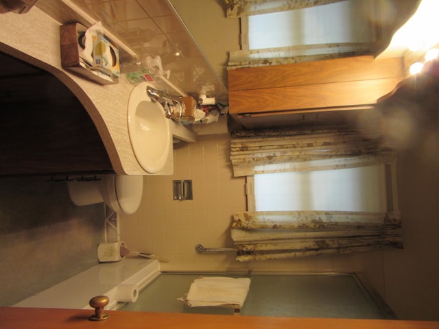 bathroom with backsplash and tile walls