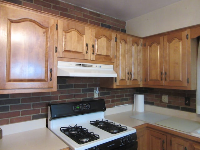 kitchen with tasteful backsplash and white range with gas cooktop