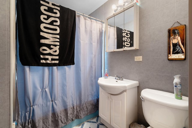 bathroom with walk in shower, vanity, toilet, and tile walls