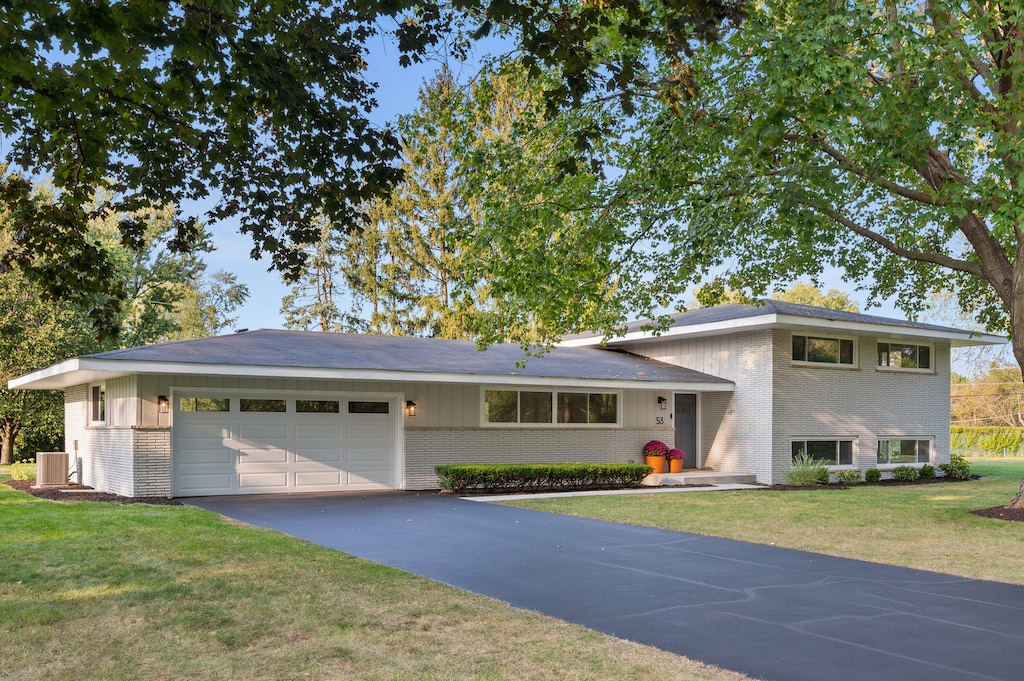 view of front of house featuring a garage and a front lawn