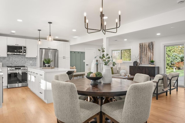 dining room with a notable chandelier and light wood-type flooring