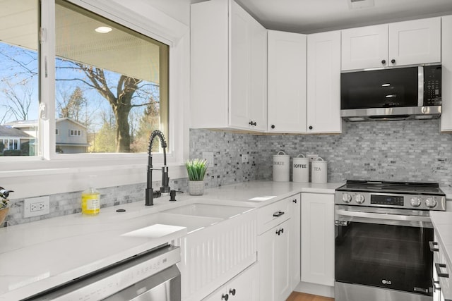 kitchen featuring backsplash, white cabinets, and appliances with stainless steel finishes