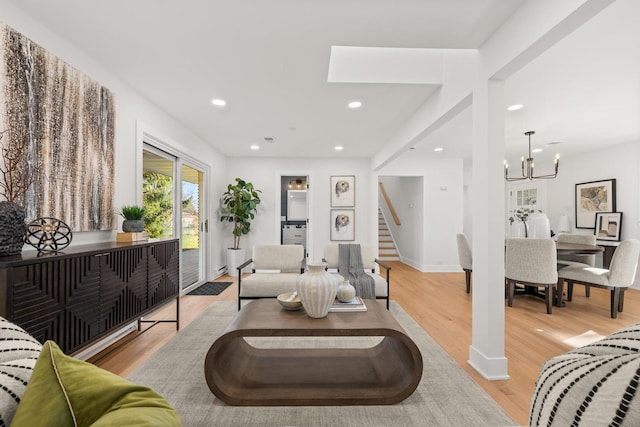 living room with light hardwood / wood-style flooring and a notable chandelier