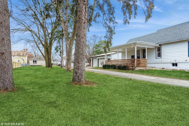 view of yard with covered porch and a garage