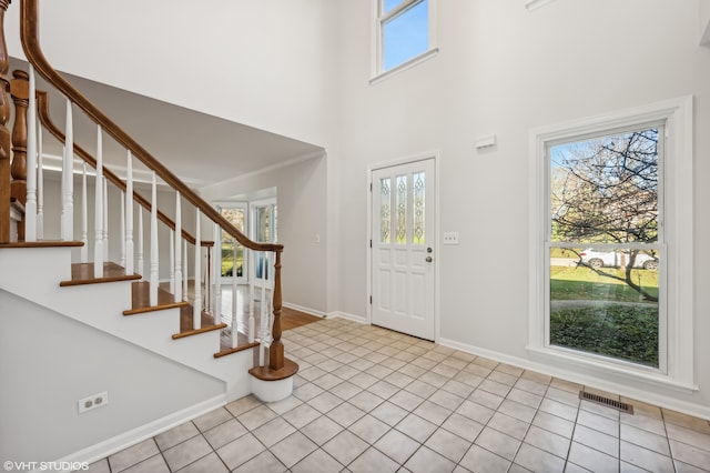 tiled foyer entrance featuring a towering ceiling and a wealth of natural light