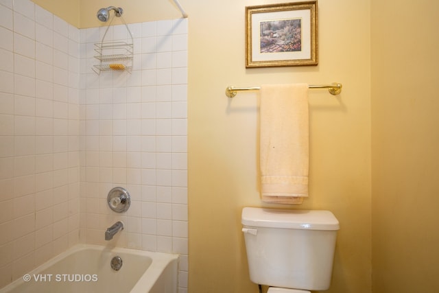 bathroom with toilet and tiled shower / bath