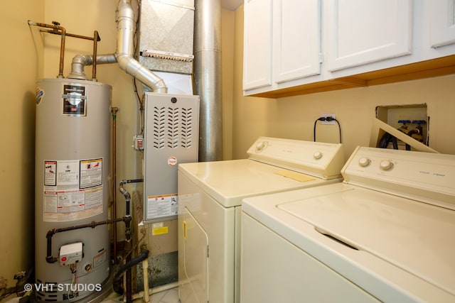 washroom featuring cabinets, independent washer and dryer, and water heater