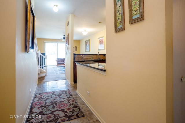 hall with sink and light tile patterned flooring