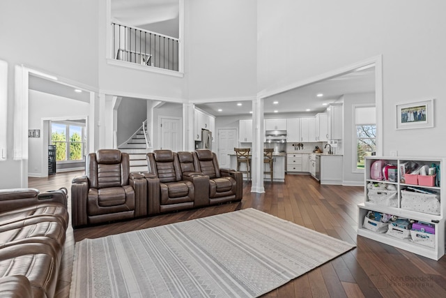 living room with ornate columns, dark hardwood / wood-style flooring, and a high ceiling