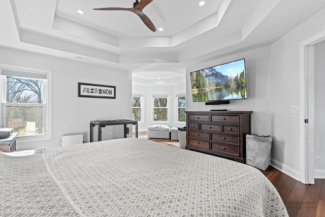 bedroom featuring a raised ceiling, ceiling fan, and dark hardwood / wood-style flooring