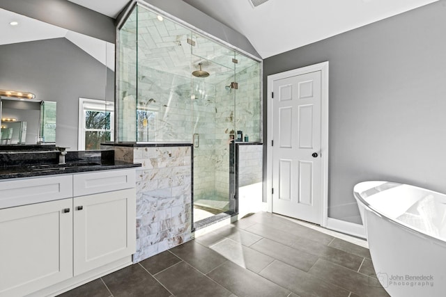 bathroom with tile patterned flooring, vanity, separate shower and tub, and vaulted ceiling