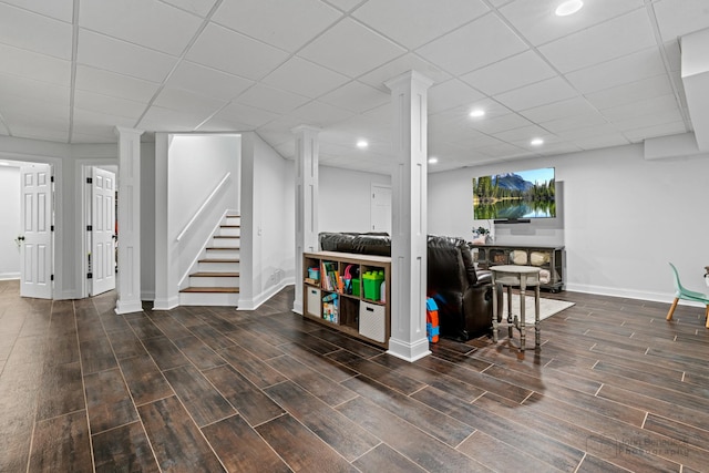 basement featuring a paneled ceiling and dark wood-type flooring