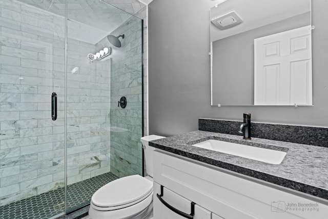 bathroom with vanity, toilet, and a shower with shower door