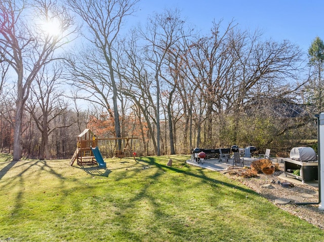 view of yard featuring a playground and a patio