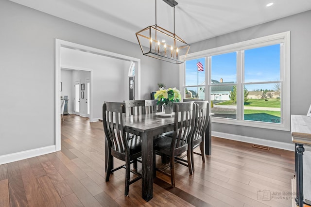 dining room featuring dark wood-type flooring and a notable chandelier