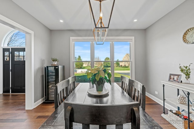 dining area with a healthy amount of sunlight, beverage cooler, and dark hardwood / wood-style floors