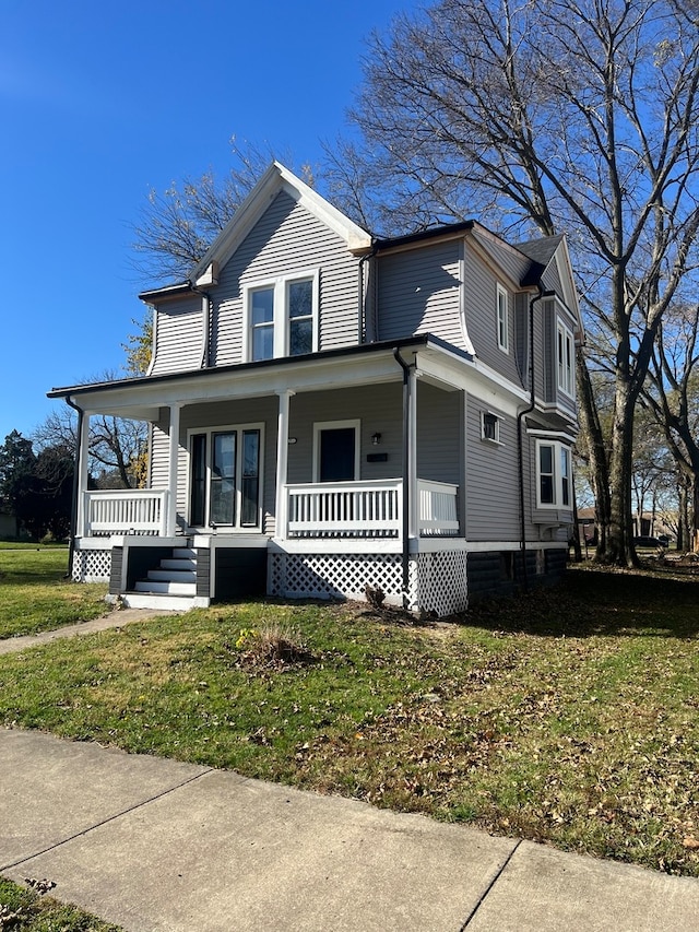 view of front of house with covered porch and a front lawn