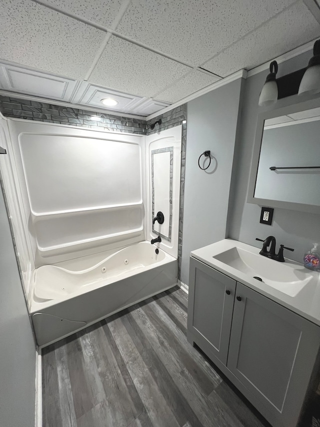 bathroom featuring vanity, wood-type flooring, a paneled ceiling, and tub / shower combination