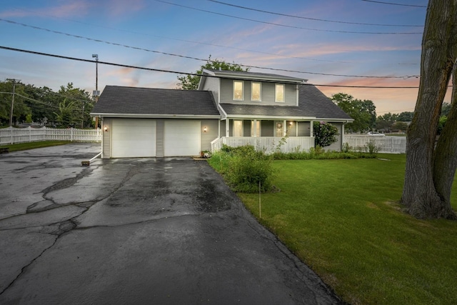 view of front facade featuring a yard, a garage, and a porch