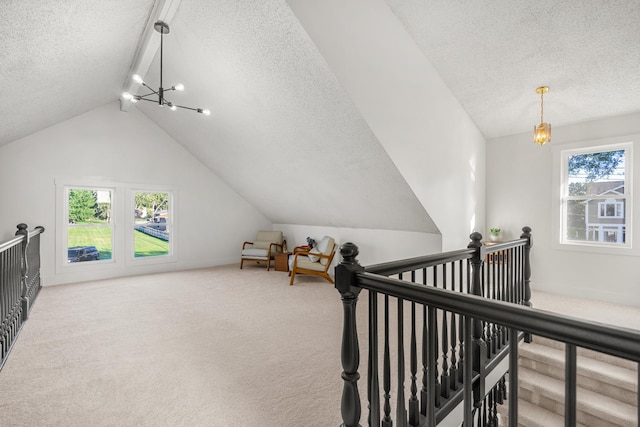 interior space with a notable chandelier, vaulted ceiling, carpet, and a textured ceiling