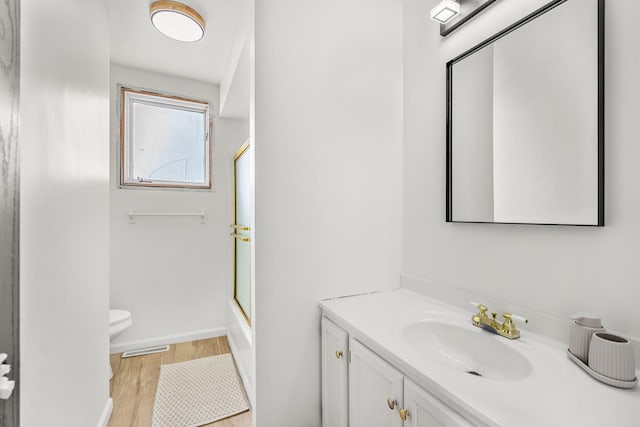 bathroom with vanity, wood-type flooring, toilet, and walk in shower