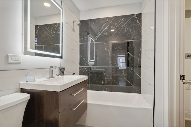 full bathroom with vanity, tiled shower / bath combo, and toilet