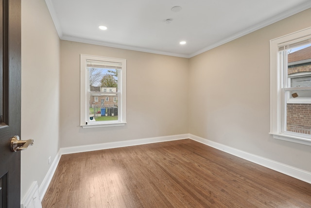 spare room with hardwood / wood-style flooring and crown molding