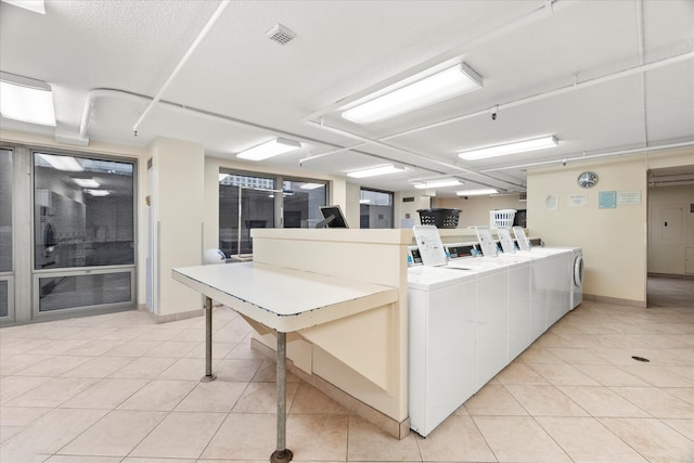 clothes washing area featuring light tile patterned floors and washer and dryer