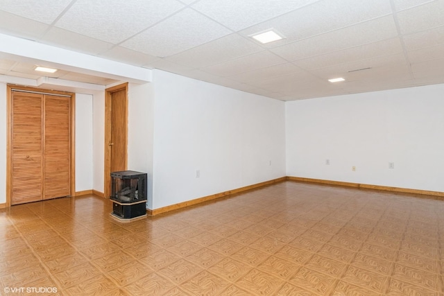 13482 S Silverleaf Rd, Plainfield, IL 60544 - unfurnished room with a wood stove, a paneled ceiling, light floors, and baseboards