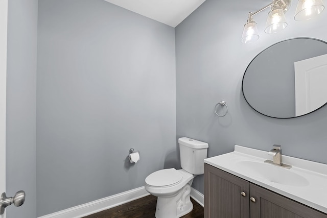 bathroom with vanity, toilet, and wood-type flooring